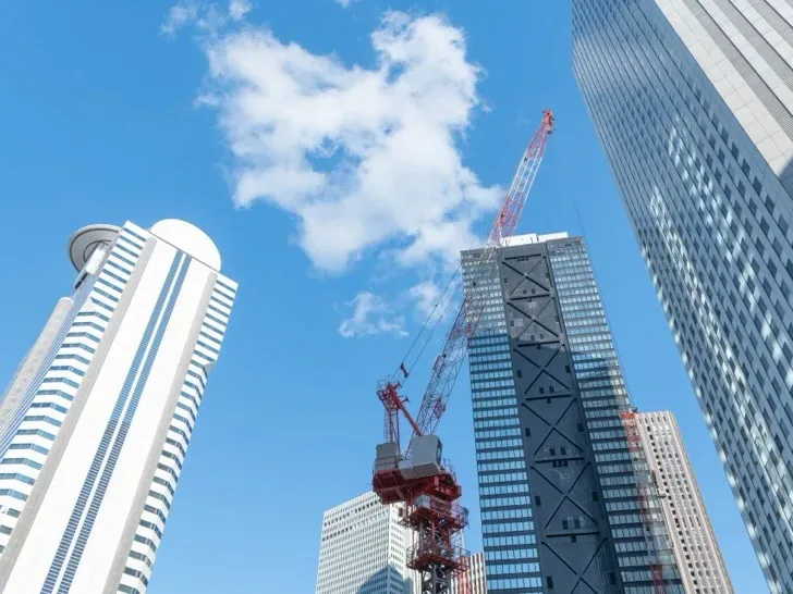 青空と高層ビル群、建設用クレーン