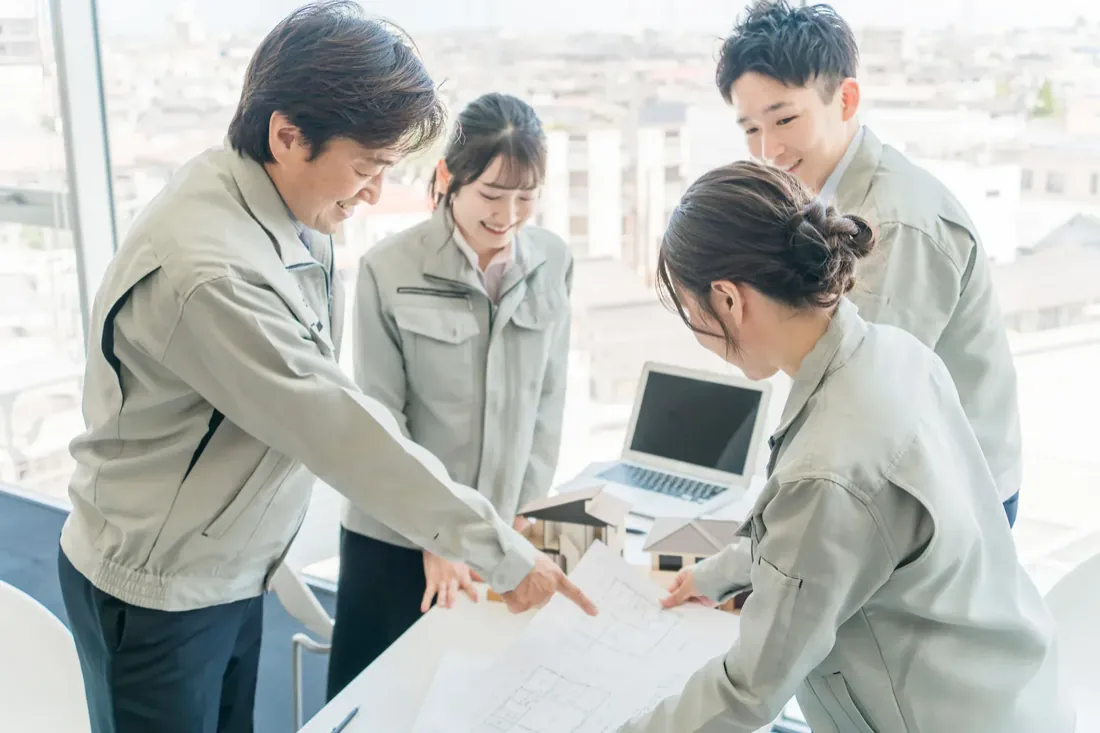 チームでパソコンを囲んで話し合うスタッフ
