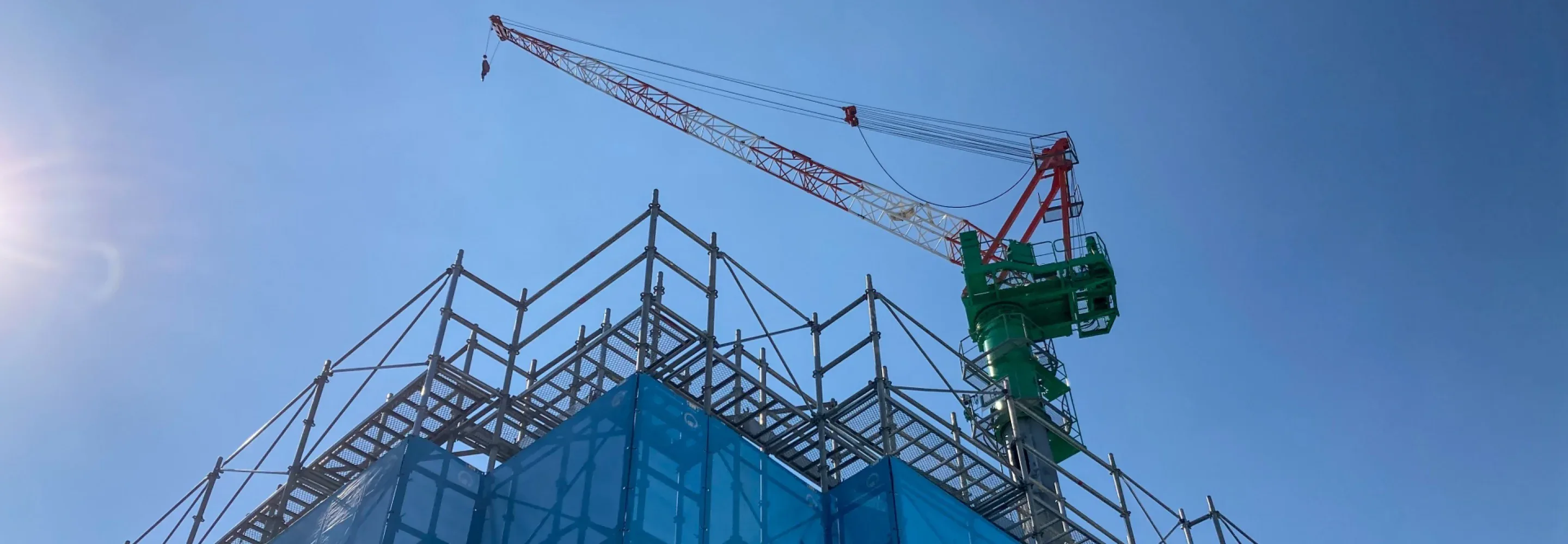建設現場のクレーンと青空の写真