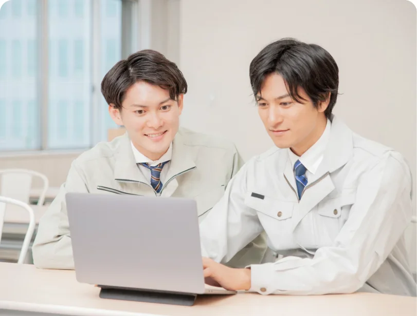 ノートパソコンを見ながら話し合うスタッフ